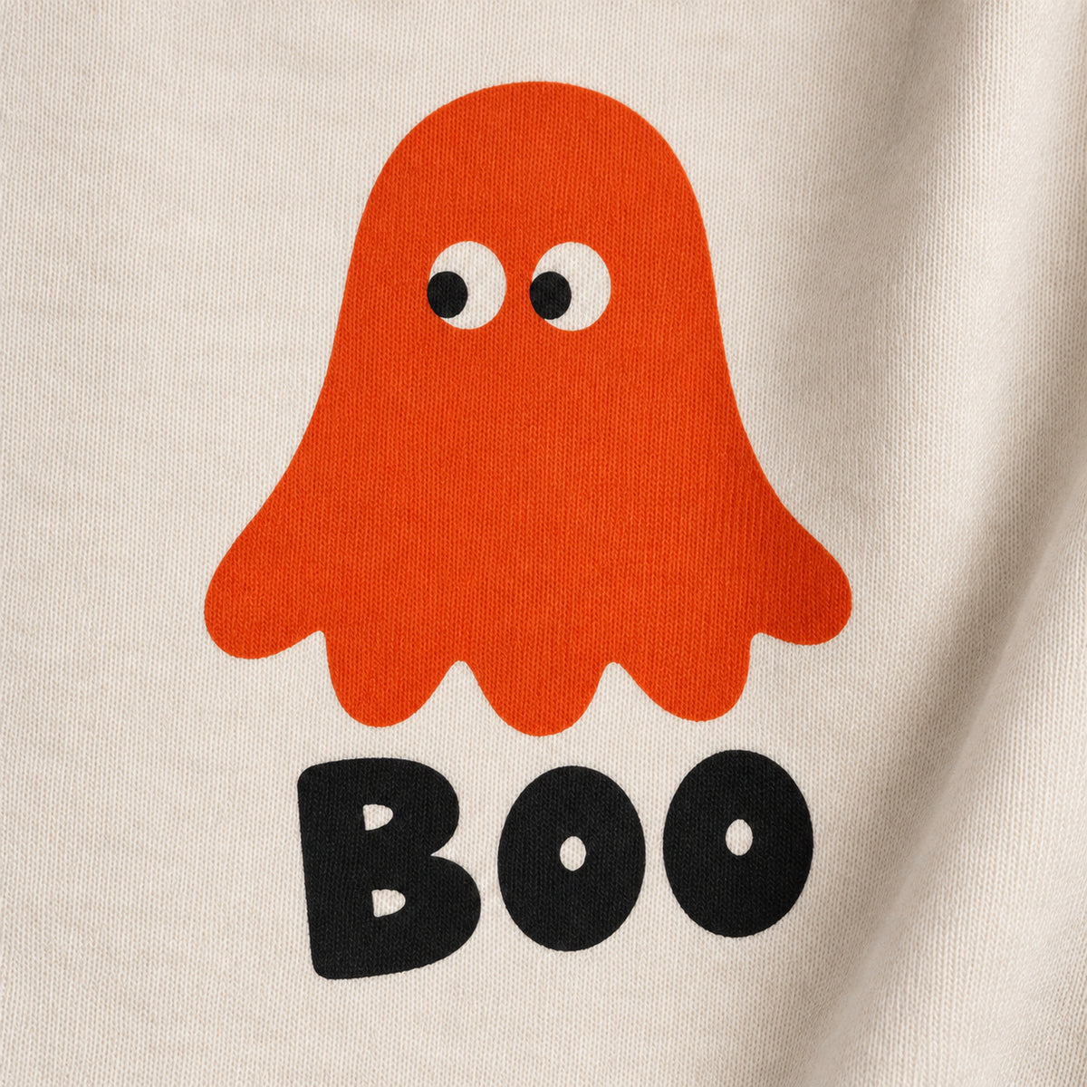 Close-up of an orange ghost and black BOO lettering printed on cream sweatshirt fabric.