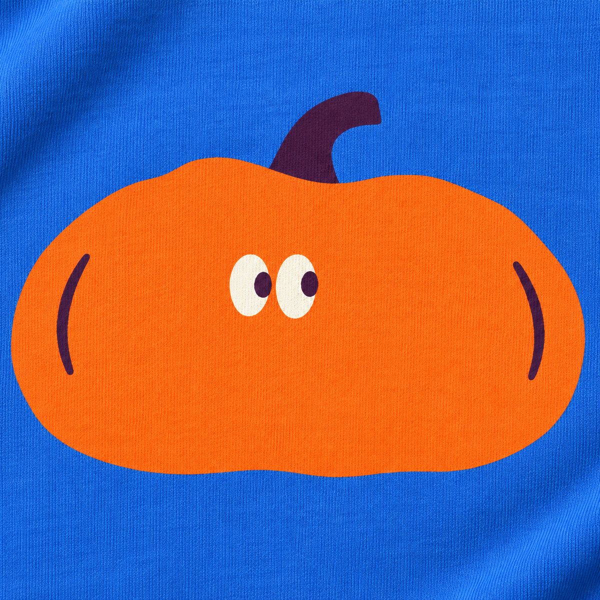 Close-up of the orange pumpkin with a plum-coloured stalk and two eyes, printed on blue sweatshirt fabric.