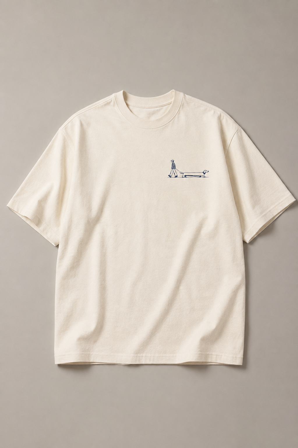 Long Walks Natural Raw organic cotton T-shirt laid flat, showing the small navy walker and dachshund chest print.